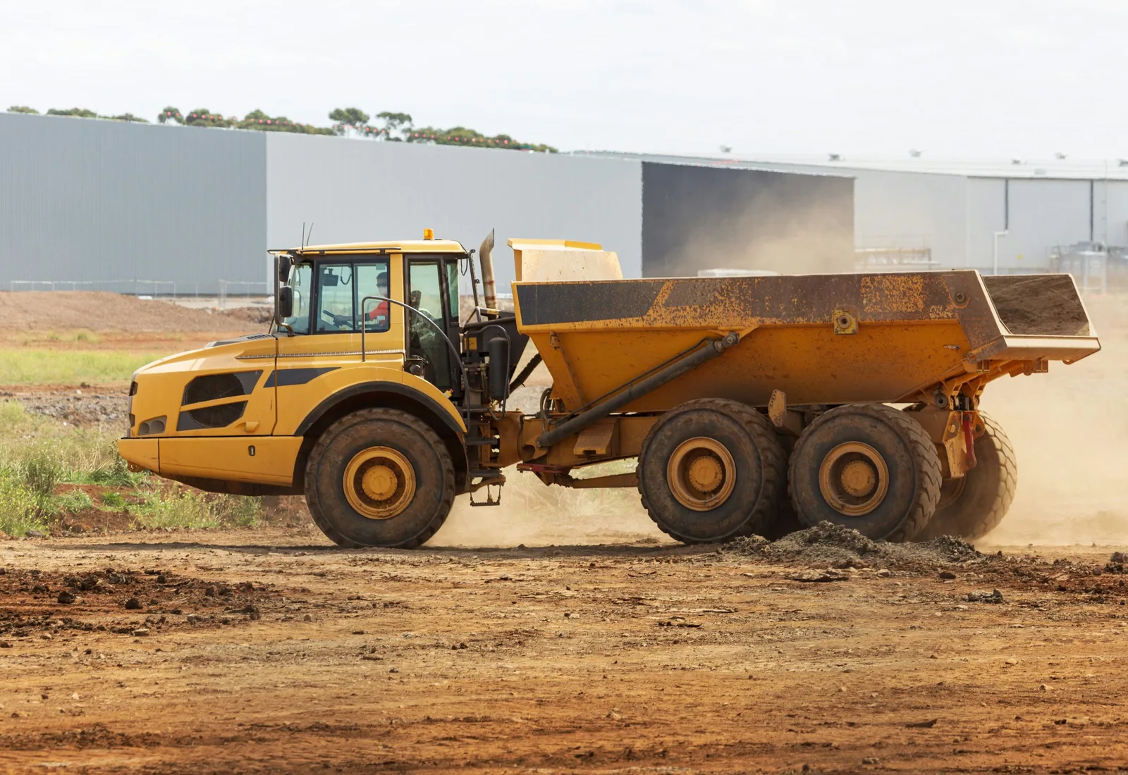 Articulated haul truck moving a load of dirt across a work site