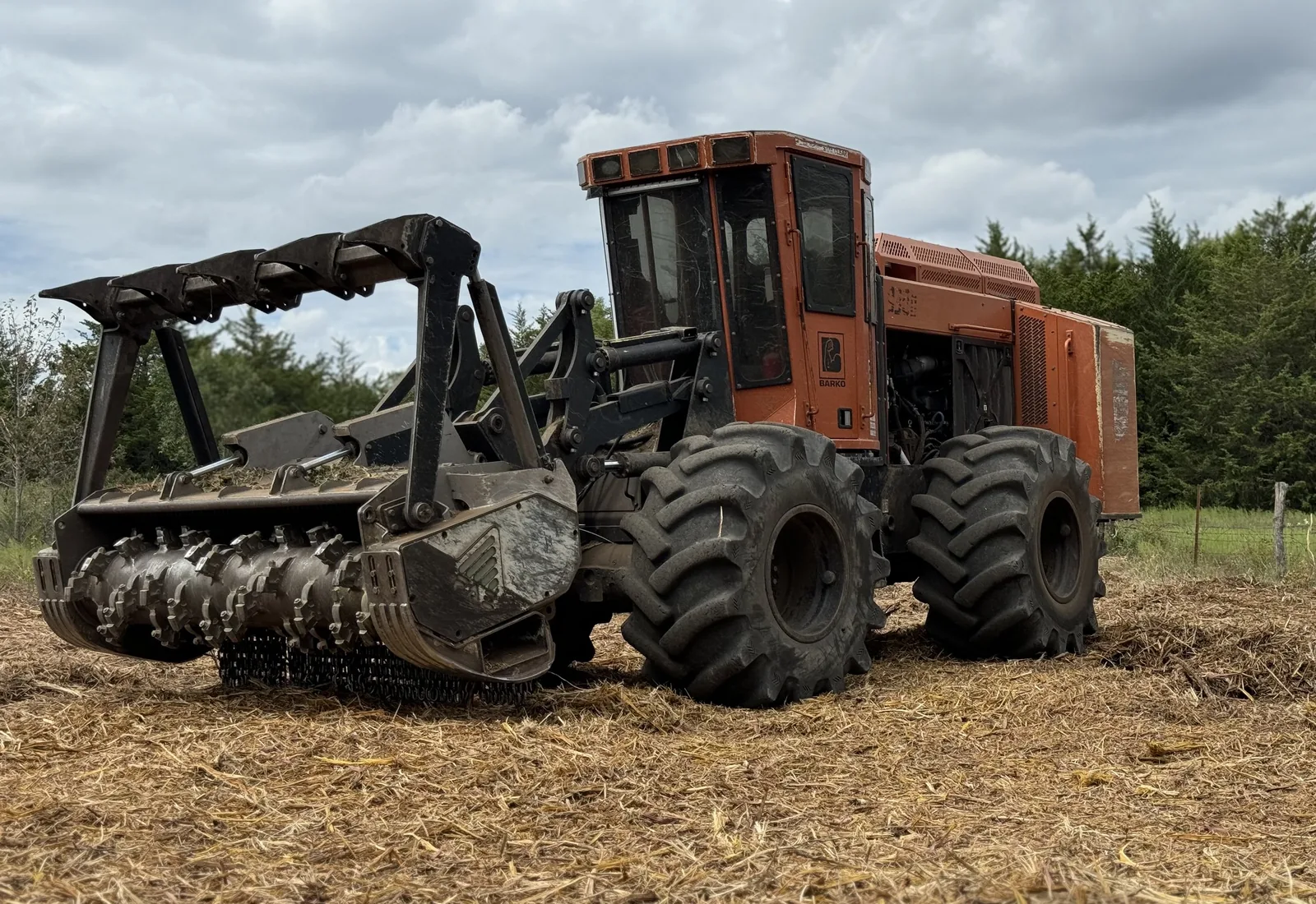 Wheeled forestry mulcher with a drum head parked on freshly mulched ground